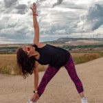 Outdoor fitness scene of a woman stretching on a dirt path in Soto de Cerrato amidst scenic landscapes.